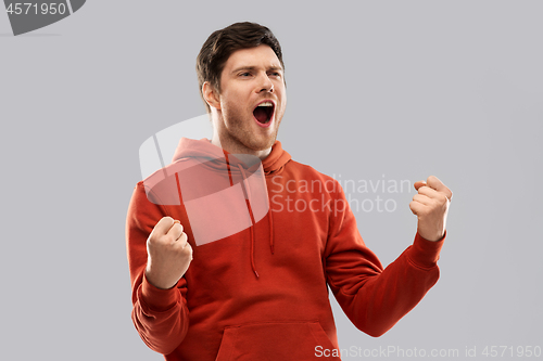 Image of happy man celebrating and making fist pump gesture