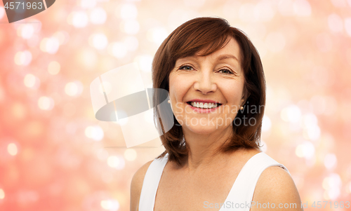 Image of portrait of smiling senior woman over white