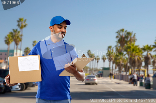 Image of indian delivery man with parcel box and clipboard