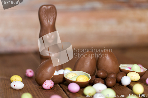 Image of chocolate eggs, easter bunny and candies on wood