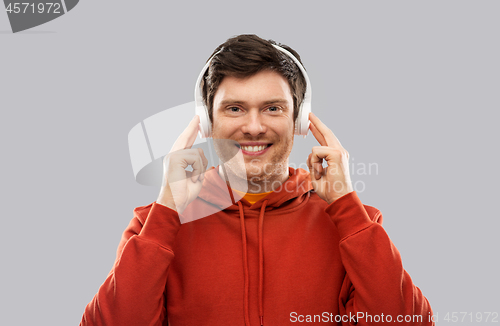 Image of happy young man in headphones and red hoodie