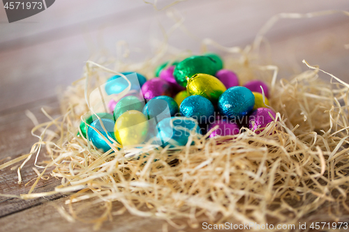 Image of chocolate eggs in foil wrappers in straw nest