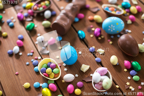 Image of chocolate eggs, easter bunny and candies on wood