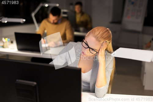 Image of tired businesswoman working at night office