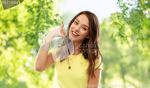 Image of young woman or teenage girl showing call gesture