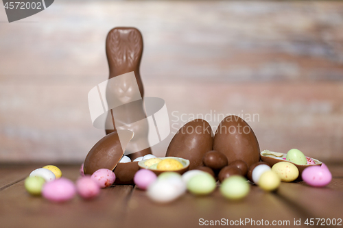 Image of chocolate eggs, easter bunny and candies on wood