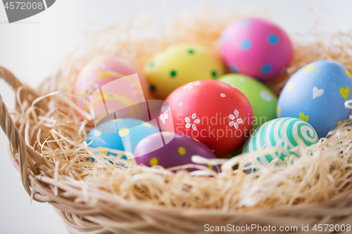 Image of close up of colored easter eggs in basket