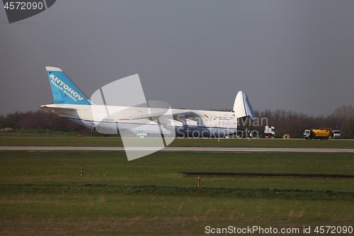 Image of BUDAPEST, HUNGARY - APRIL 16: Antonov An-124 cargo plane at Budapest Airport on April 16, 2013. The aircraft is being loaded by an oversize truck with 100 tons of cargo.