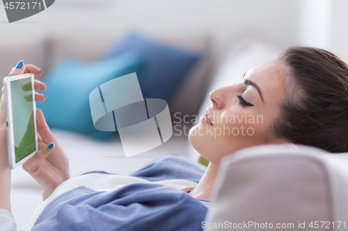 Image of woman on sofa using tablet computer