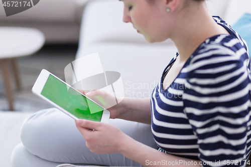 Image of woman on sofa using tablet computer