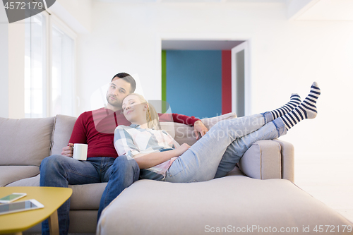 Image of couple hugging and relaxing on sofa