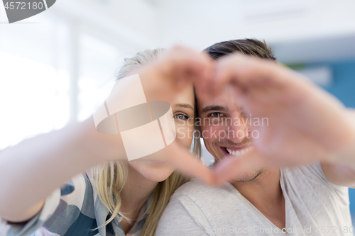 Image of couple making heart with hands