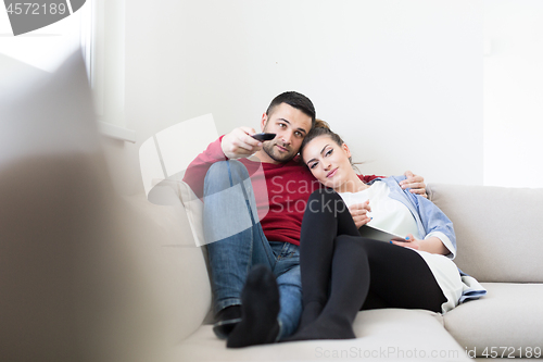 Image of Young couple on the sofa watching television