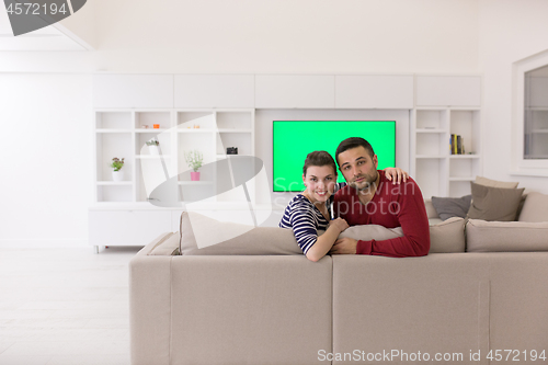 Image of couple hugging and relaxing on sofa
