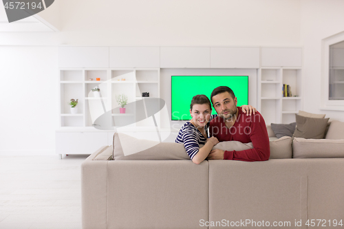 Image of couple hugging and relaxing on sofa