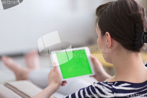 Image of woman on sofa using tablet computer