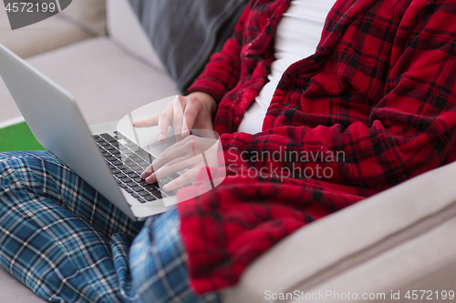 Image of man freelancer in bathrobe working from home