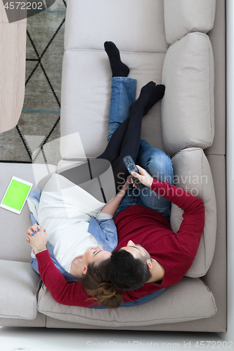 Image of Young couple on the sofa watching television top view