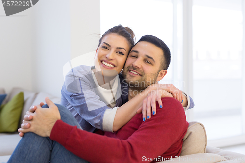 Image of couple hugging and relaxing on sofa