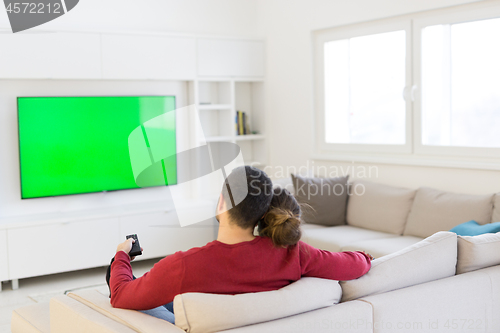 Image of Young couple on the sofa watching television