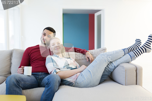 Image of couple hugging and relaxing on sofa