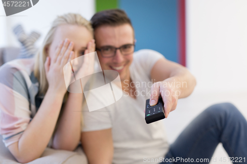 Image of Young couple on the sofa watching television