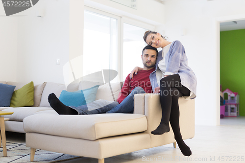 Image of couple hugging and relaxing on sofa