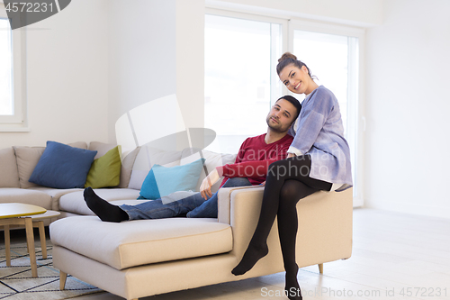 Image of couple hugging and relaxing on sofa