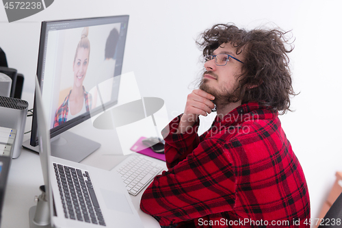 Image of graphic designer in bathrobe working at home