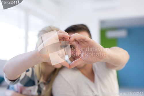 Image of couple making heart with hands