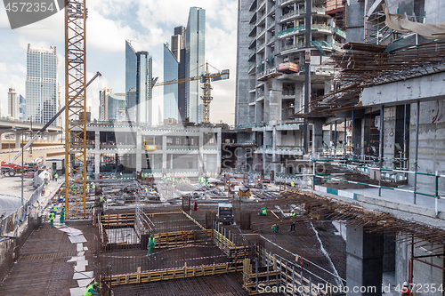 Image of Laborers working on modern constraction site works in Dubai. Fast urban development consept