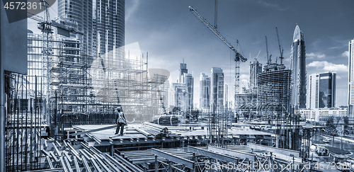 Image of Laborers working on modern constraction site works in Dubai. Fast urban development consept