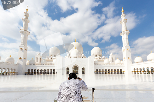 Image of Male tourist taking photo Sheikh Zayed Grand Mosque in Abu Dhabi, the capital city of United Arab Emirates