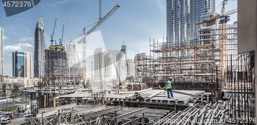 Image of Laborers working on modern constraction site works in Dubai. Fast urban development consept