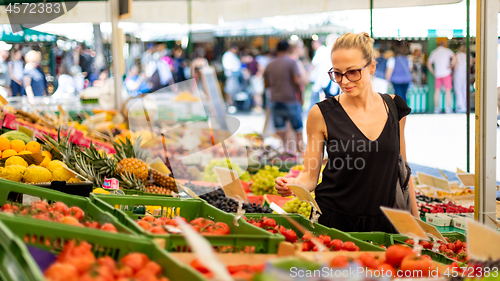 Image of Woman buying fruits and vegetables at local food market. Market stall with variety of organic vegetable