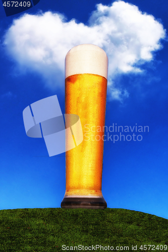 Image of Wheat beer glass on green meadow