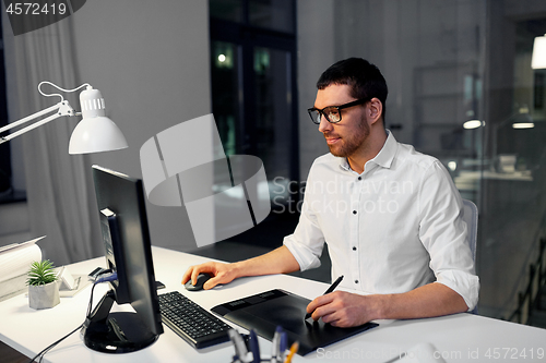 Image of designer with computer and pen tablet at office