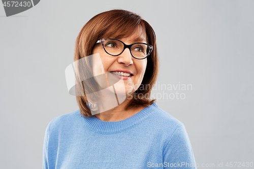 Image of portrait of senior woman in glasses over grey