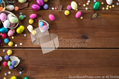 Image of chocolate eggs and candy drops on wooden table