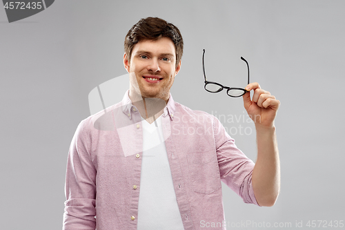 Image of smiling man with glasses over grey background