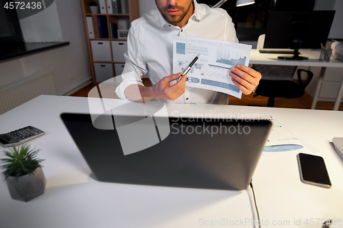 Image of businessman having video chat at night office