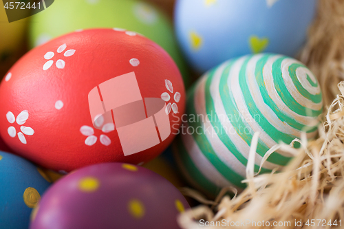 Image of close up of colored easter eggs in straw