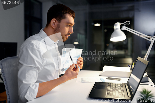 Image of businessman having video chat at night office