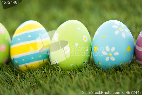 Image of row of colored easter eggs on artificial grass