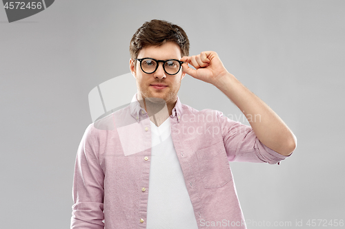 Image of young man in glasses over grey background