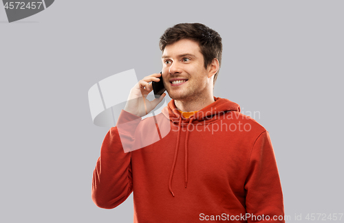 Image of young man in red hoodie calling on smartphone