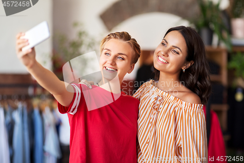 Image of female friends taking selfie at clothing store