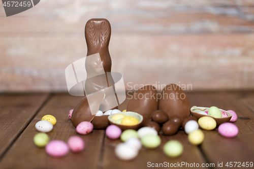 Image of chocolate eggs, easter bunny and candies on wood