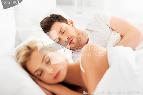 Image of happy couple sleeping in bed at home