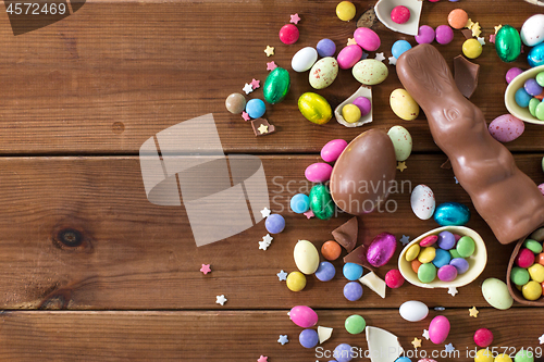 Image of chocolate eggs, easter bunny and candies on wood